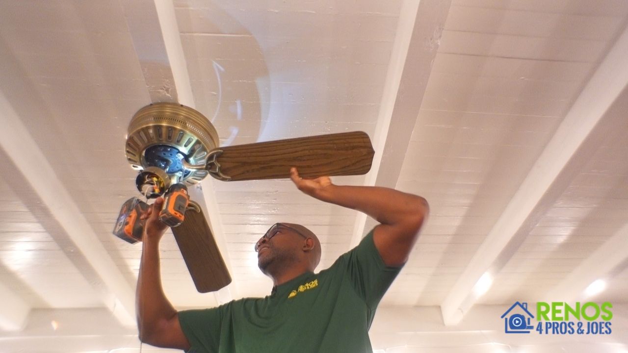 man removing an old ceiling fan